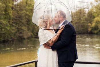 Hochzeitspaar glücklich unterm Regenschirm